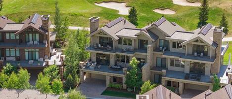 Un edificio residencial de varios pisos con un campo de golf al fondo.