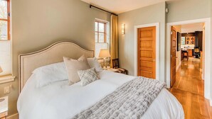 A bedroom with a large bed, a bedside table, a lamp, and a view of the hallway. - Abode at Ketchum Escape, walk to Main St, ensuites (Ketchum)