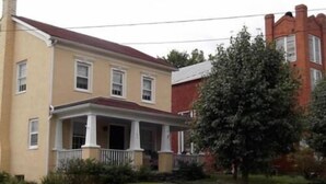 A two-story house with a porch, a chimney, and a tree in the front yard. - Schilling House (Bolivar)