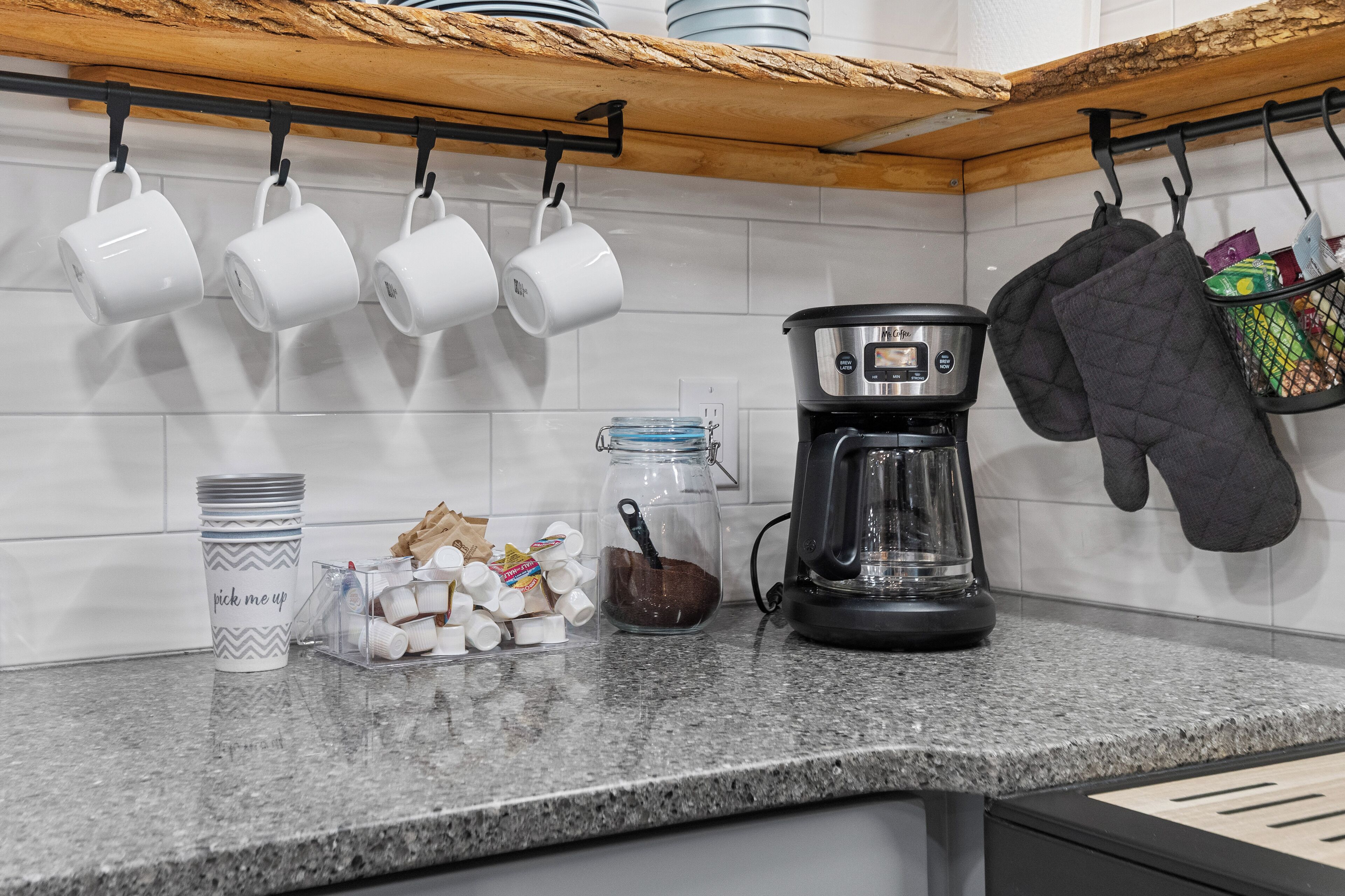 Een keukentrap met een koffiezetapparaat, mokken en keukengerei.