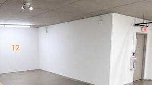 Eine saubere, leere Tiefgarage mit Betonboden, weißen Wänden und einem sichtbaren Ausgangsschild.