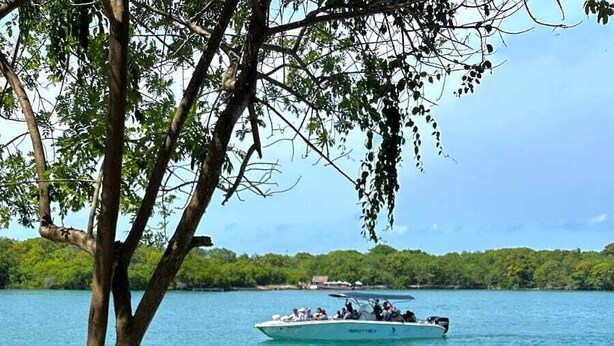 En avslappningshörna med utsikt över en sjö och en båt.
