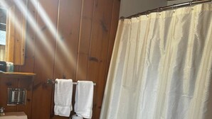 A bathroom with a toilet, sink, and shower curtain. - Cozy 1BR hotel room, Hamilton - #336 Endawonnda (Hamilton)