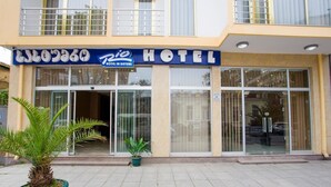 A hotel with a signboard, large windows, and potted plants in front. - Rio Batumi (Batumi)