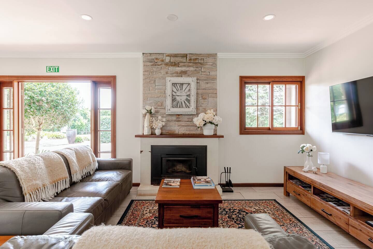 A living room with a fireplace, a sofa, a coffee table, and a TV.