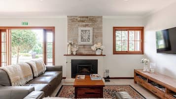 A living room with a fireplace, a sofa, a coffee table, and a TV.