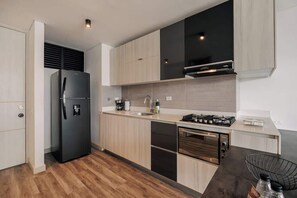 Een moderne keuken met een geïntegreerde koelkast, fornuis, oven en vaatwasser.