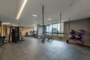 A gym with exercise equipment, large windows, and a high ceiling. - lEPl Modern Loft in El Poblado W/pool & Gym (Medellín)