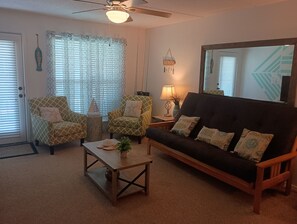 A living room with a sofa, two armchairs, a coffee table, and a ceiling fan. - Seascape Escape 304 (South Padre Island)