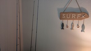 Ein Zimmer mit einer Angel, einem Schild mit Surfmotiv und einer Lampe.