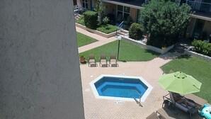 Ein Poolbereich auf dem Dach mit Sprungbrett, Liegestühlen und Sonnenschirm.