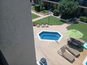 A rooftop pool area with a diving board, lounge chairs, and an umbrella. - Seascape Escape 304 (South Padre Island)
