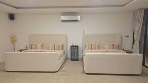 Ein Hotelzimmer mit zwei Betten, einer Minibar und einer Klimaanlage.