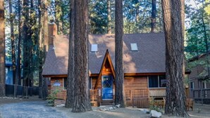 A cabin with a wooden exterior, a front porch, and a chimney. - Cozy Cabin Near Snow Summit w Loft & Fireplace (Big Bear Lake)
