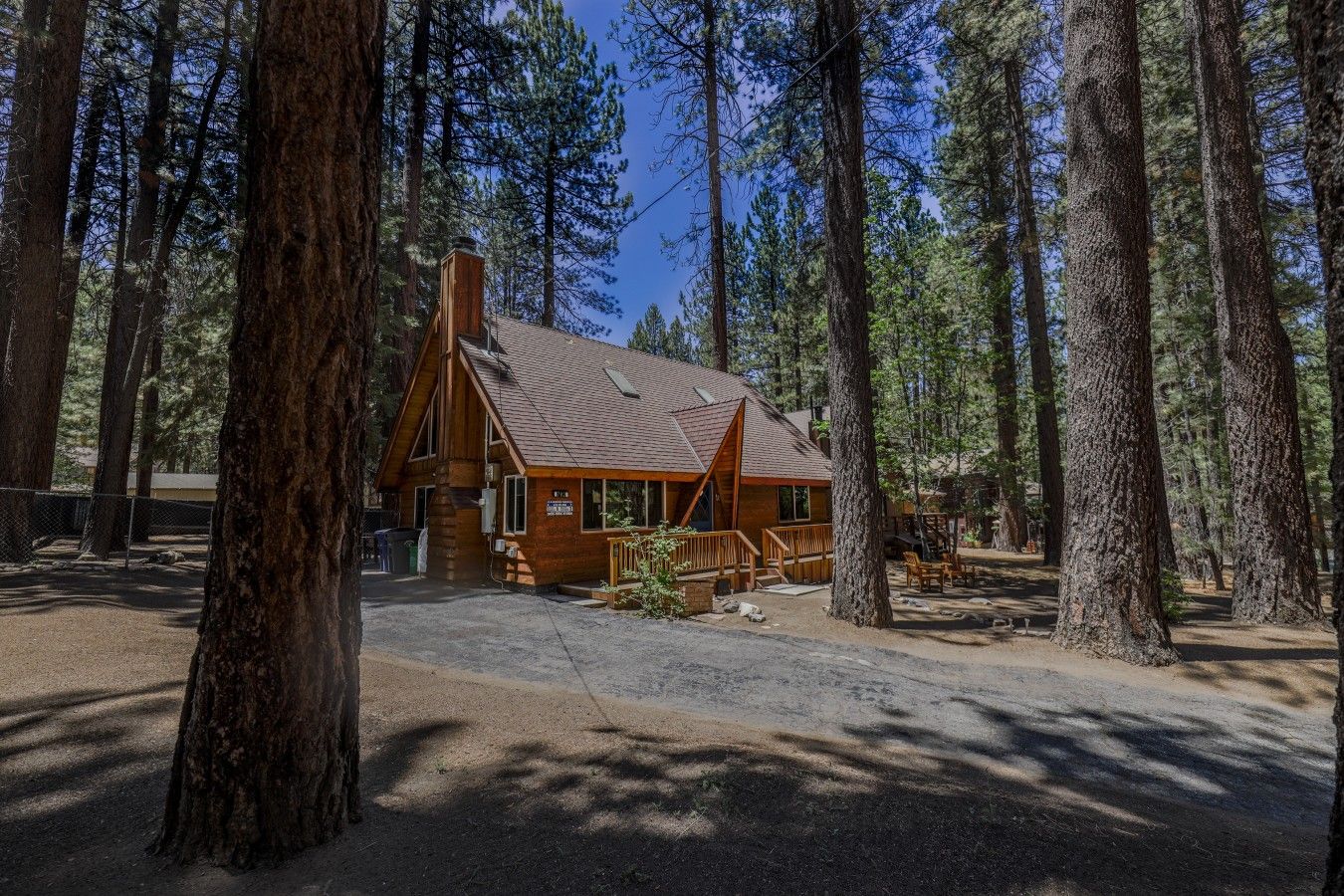 A lodge with a wooden exterior, a chimney, and a deck area.