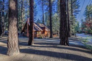 A cabin surrounded by tall trees, with a gravel driveway leading to the entrance. - Chairlift Cabin Near Snow Summit w Loft & Fireplace (Big Bear Lake)