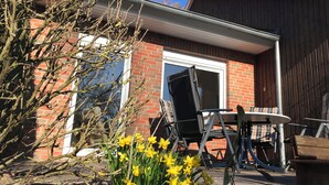 Un espace patio avec une maison en briques, une table et des chaises.