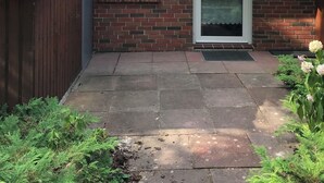 Une maison en briques avec un toit en tuiles, une petite fenêtre et une porte.
