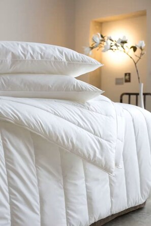 A bed with white bedding and a bedside lamp. - Wonderful 2-beds with AC by Leicester Square (London)