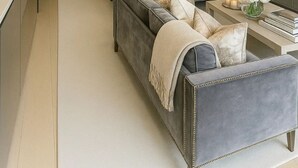 Un salon moderne avec un canapé gris, une table basse et une bibliothèque.