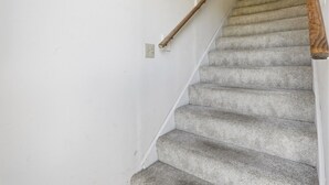 Un escalier avec une rampe en bois et un mur blanc.