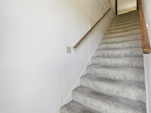Eine Treppe mit einer Holzhandläufe und einer weißen Wand.