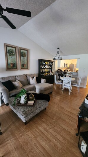 A living room with a sofa, a coffee table, and a dining area with a table and chairs. - Florida Fun Villa in the heart of Oldsmar between Tampa and Clearwater (Oldsmar)