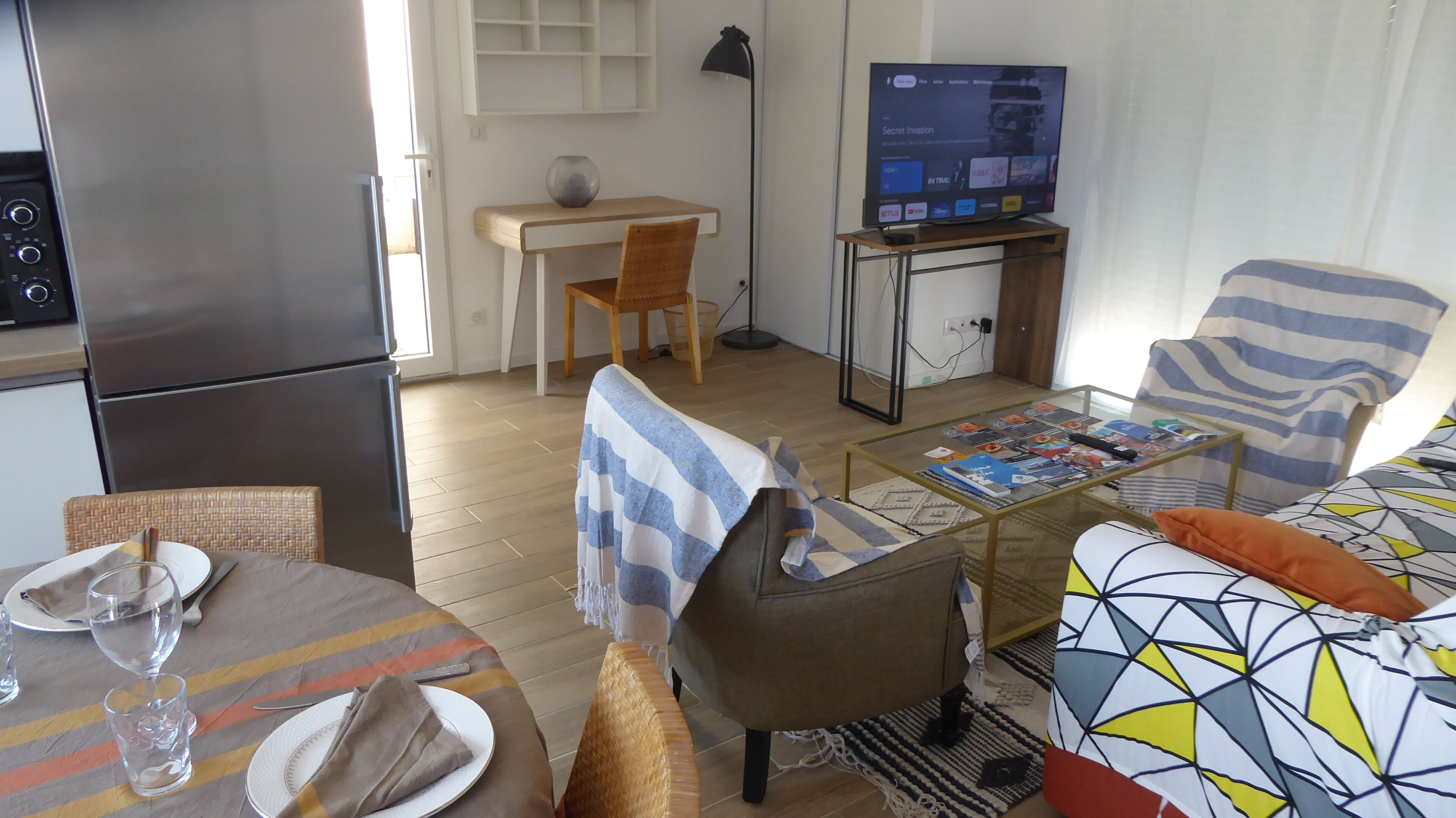 Ein kompakter Wohnbereich mit Küchenzeile, Essbereich und einer Sitzecke mit Fernseher.