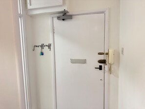 Una puerta blanca con un ojo de cerradura, un cerrojo y un picaporte.