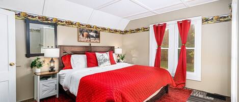 A hotel room with a bed, nightstands, a mirror, and a window with curtains.