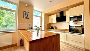 A modern kitchen with a central island, built-in appliances, and large windows. - Spacious 1 bedroom with 4 beds  (Luxembourg)