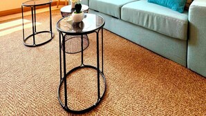 A modern living room with a grey sofa, a round glass coffee table, and a lamp. - Spacious 1 bedroom with 4 beds  (Luxembourg)