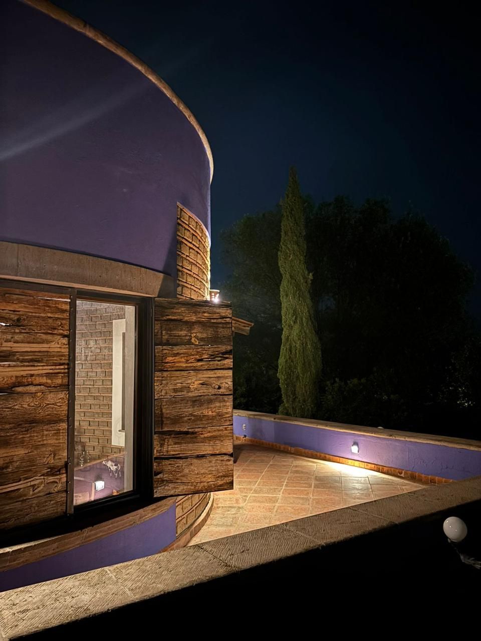 Un bâtiment moderne à l’extérieur incurvé, doté d’une fenêtre bien visible et d’un mur en briques.