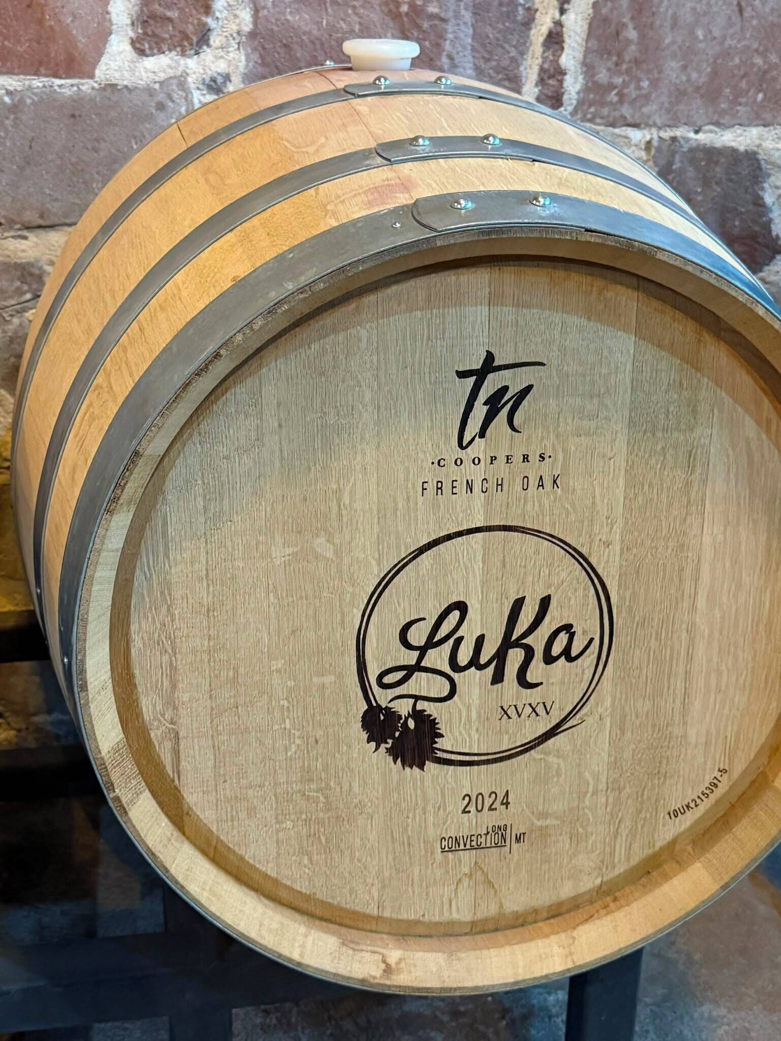 A wooden barrel with inscriptions and a date.