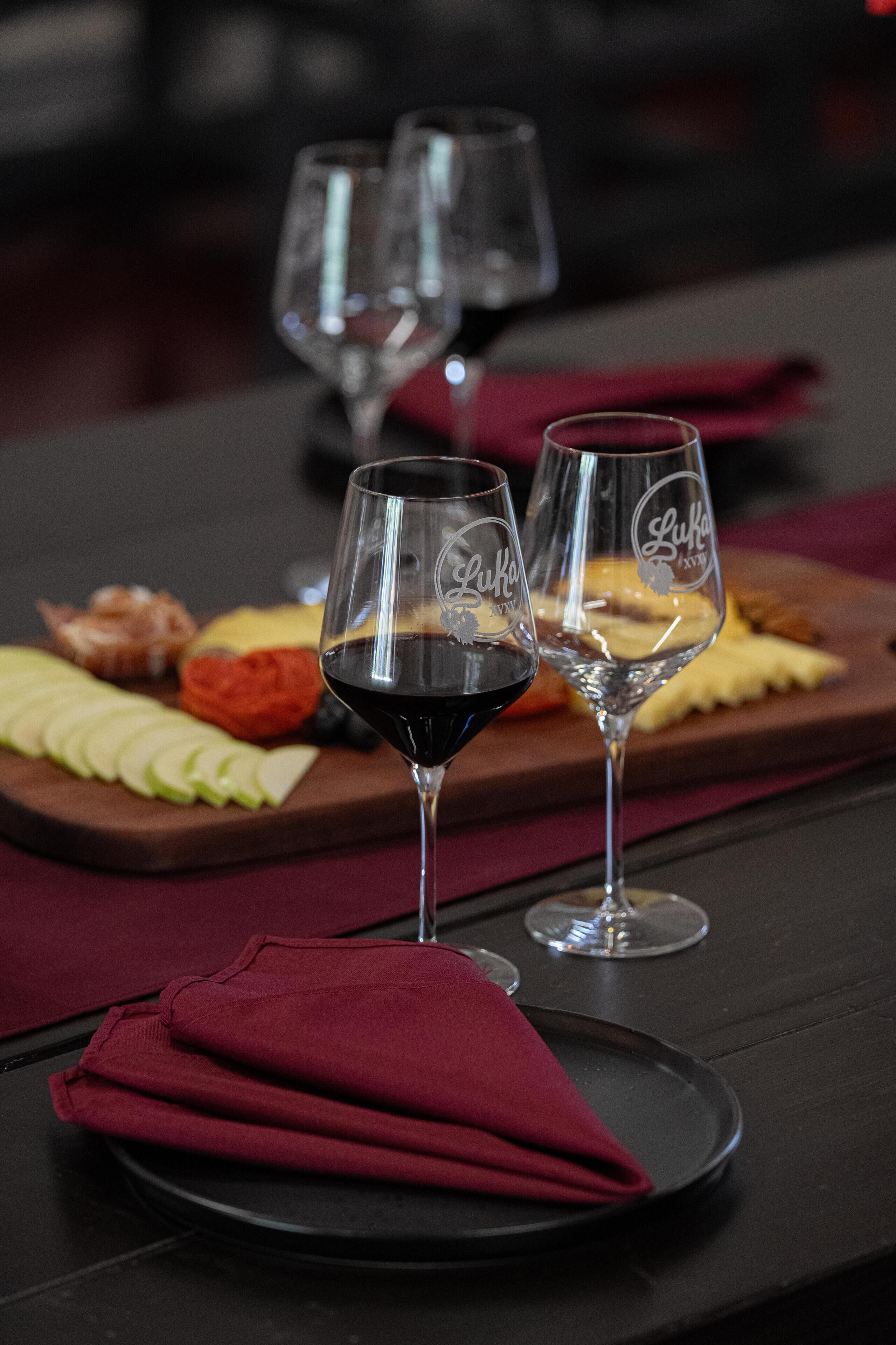 Una mesa con dos copas de vino y un plato de comida.