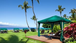 Ein Strandresort mit überdachter Lounge, Liegestühlen und Blick auf das Meer.