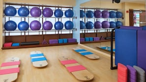 Ein Fitnessraum mit Trainingsgeräten, darunter Bälle und Gleichgewichtsbretter.