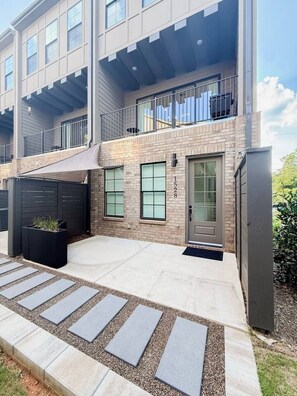 A modern two-story residential building with a flat roof, large windows, and a visible balcony. - Luxury Designer Home | Steps to NoDa | City Views (Charlotte)