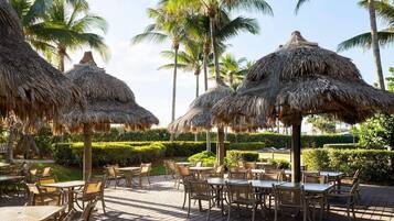 A resort with thatched umbrellas and outdoor seating.
