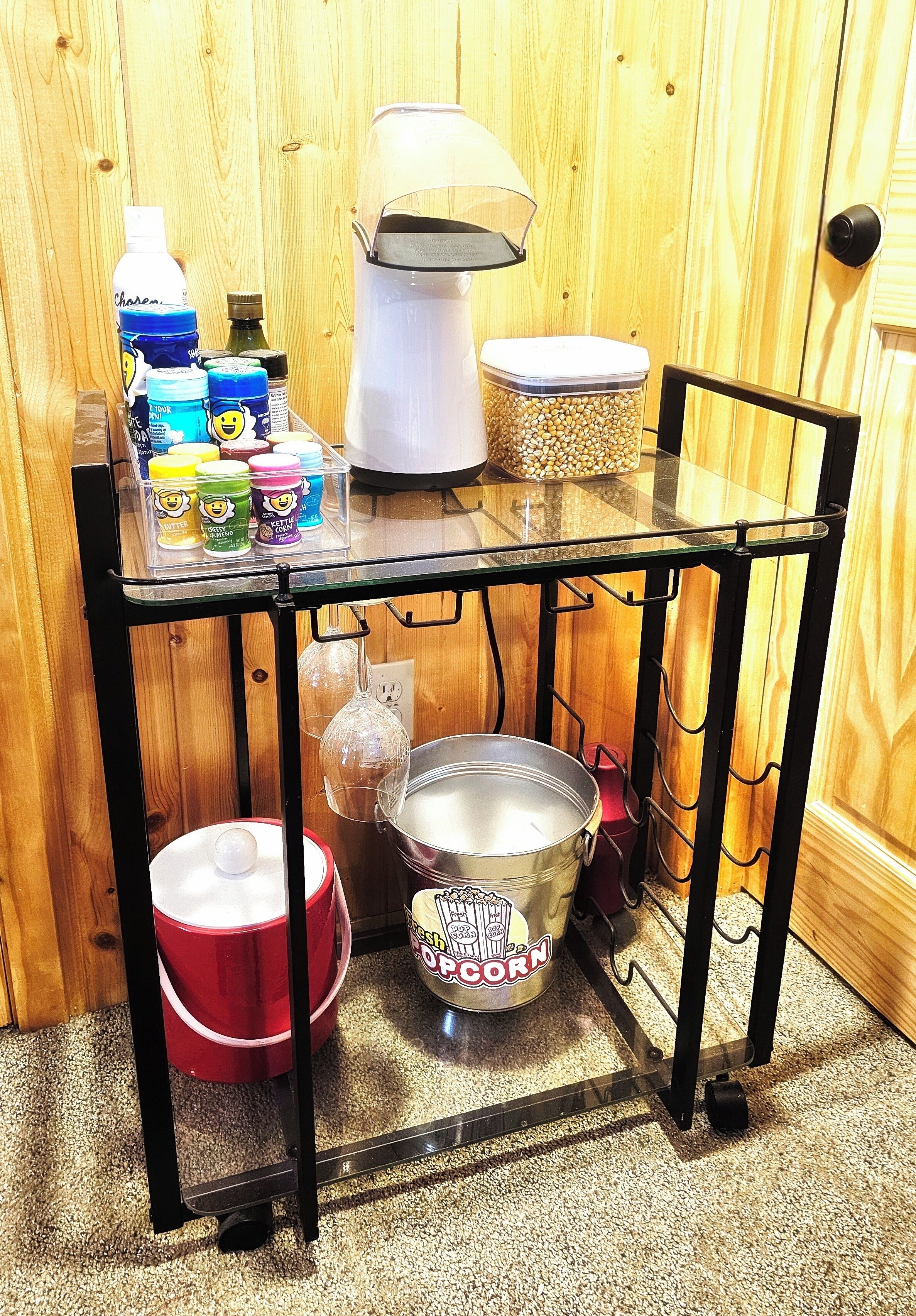 A kitchen area with a glass-top table holding various food items and containers.