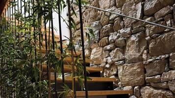 A staircase with wooden steps and a stone wall backdrop.