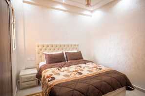 Una camera da letto con un letto, un comodino e una cassettiera.