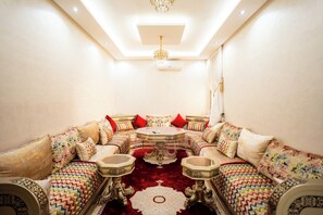 A luxurious living room with a sofa set, a round coffee table, and decorative elements. - Authentic Moroccan Apt 2BR 8 min Airport AC and Parking Marrakech (Marrakech)