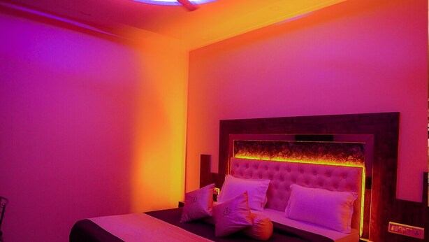 A bedroom with a bed, a nightstand, and a ceiling fan. - Hotel Royace Executive By Glitz Hotels (Mumbai)