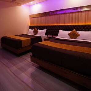 Two single beds with wooden frames and dark bedding, a headboard with vertical slats, and a wooden floor. - Hotel Royace Executive By Glitz Hotels (Mumbai)
