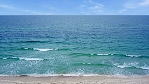 Ein Strand mit Wellen und blauem Himmel.