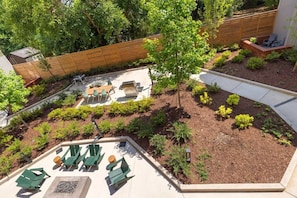 A landscaped backyard with a patio area, outdoor furniture, and a wooden fence.