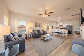 A spacious living room with a sofa, coffee table, and dining area. - Cozy Family Home, Prime Location Near Downtown (Galveston)