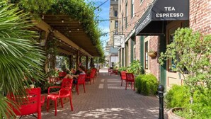 A café with outdoor seating, a sign for 'TEA ESPRESSO,' and a 'MOD' coffee shop sign. - Cozy Family Home, Prime Location Near Downtown (Galveston)