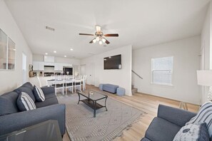 Uma sala de estar moderna com sofá, mesa de centro e área de jantar com cadeiras.